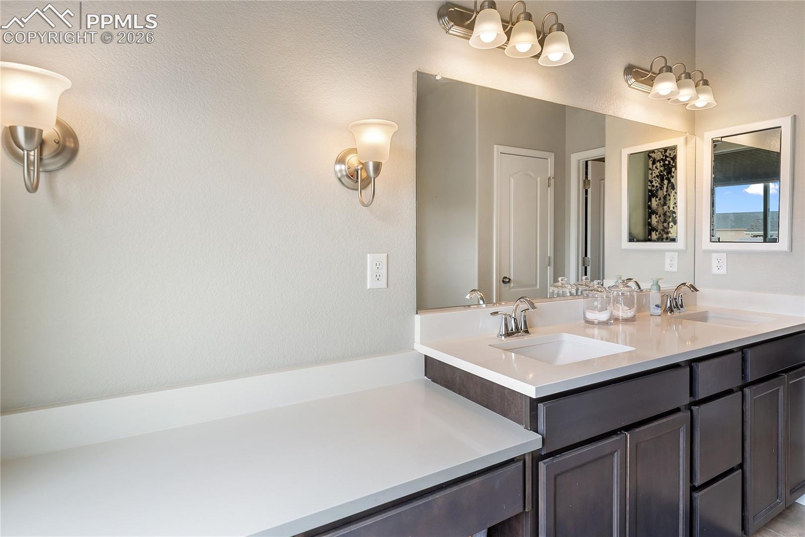 Double vanity primary bathroom with connected walk-in closet