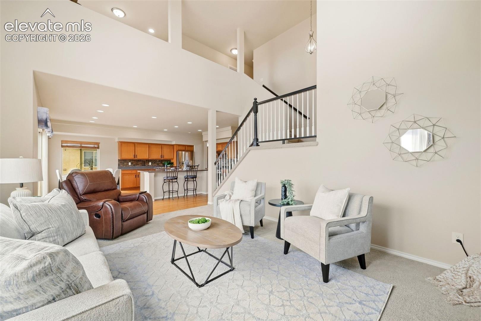 Open living room with high ceilings, tons of natural light, and a gas fireplace
