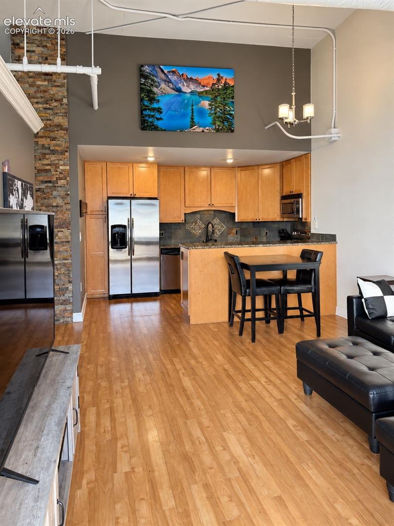 Kitchen featuring wood-finish cabinetry, stainless steel appliances, and a tiled backsplash