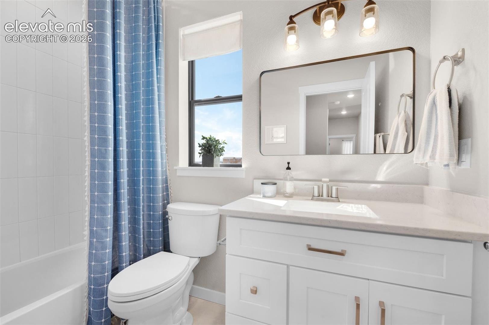 White vanity with brushed nickel hardware, integrated sink, and light-toned countertop