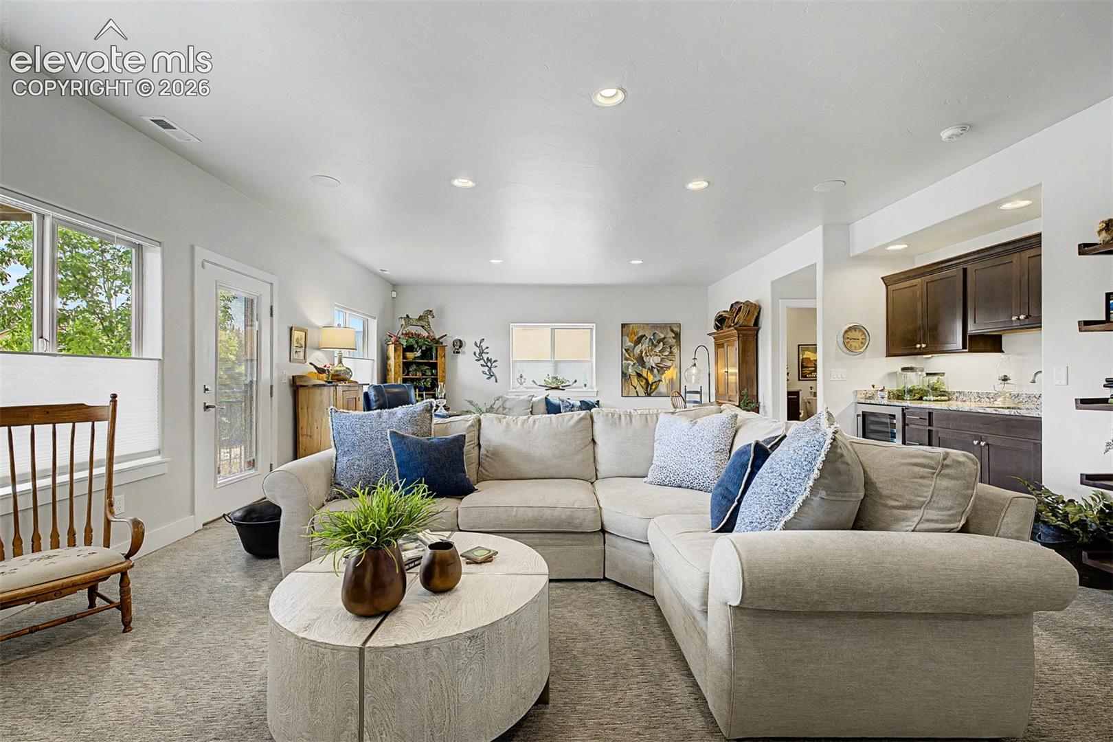 A large family room with a great wet bar, walk out to the beautiful, gated patio and a great area behind the seating area for a gaming table, billiards table or another sitting area.