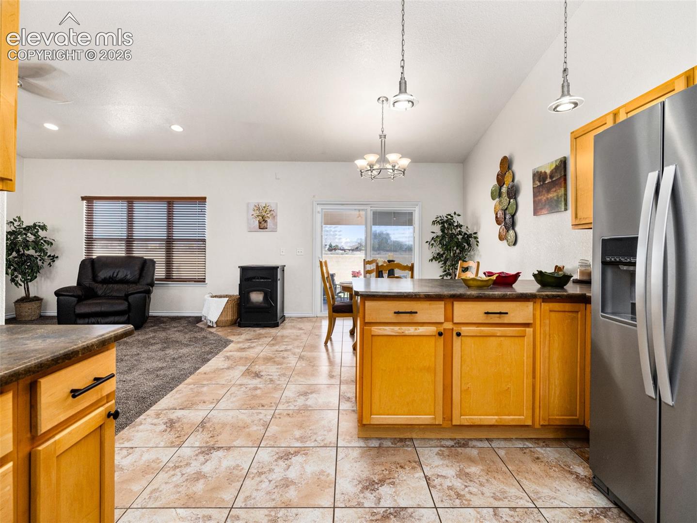 Kitchen island with wood cabinetry and dark countertops