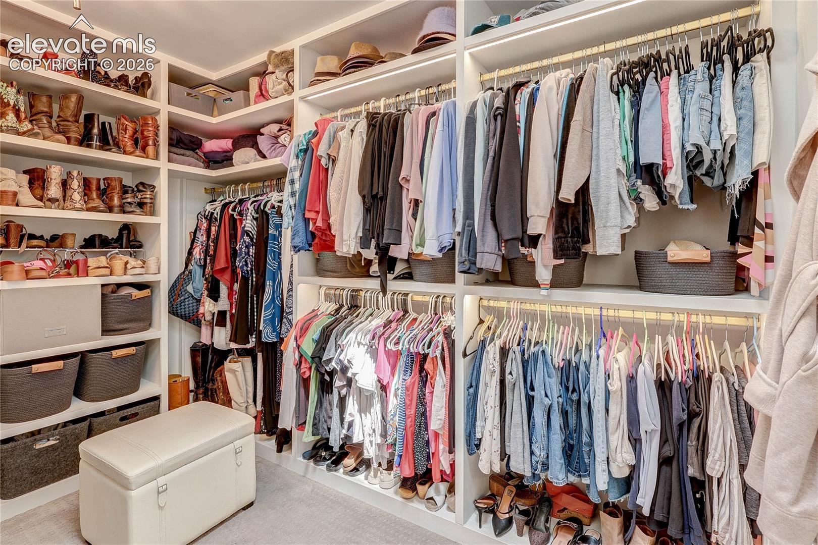 Custom closet system featuring built-in shelving, clothing rods, and integrated lighting