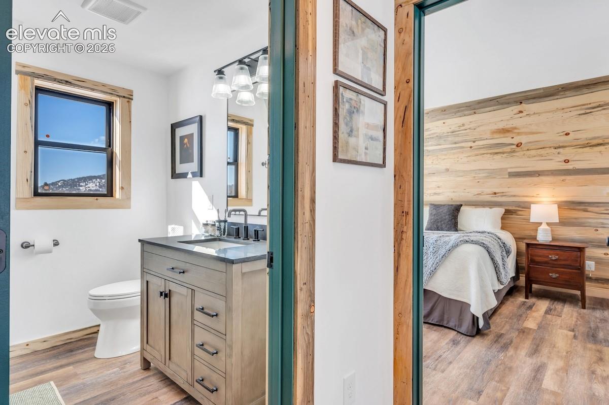 Bathroom vanity with a stone countertop, under-mount sink, and dark hardware