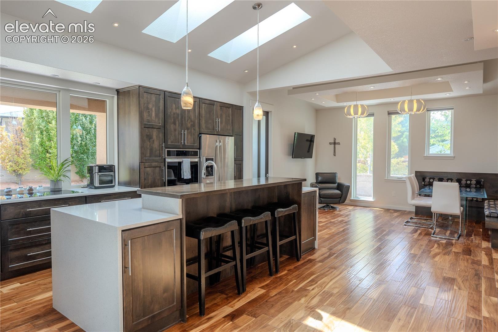 This kitchen has it all. Custom cabinetry, waterfall quartz counters, bar seating, plenty of natural light, walk in pantry