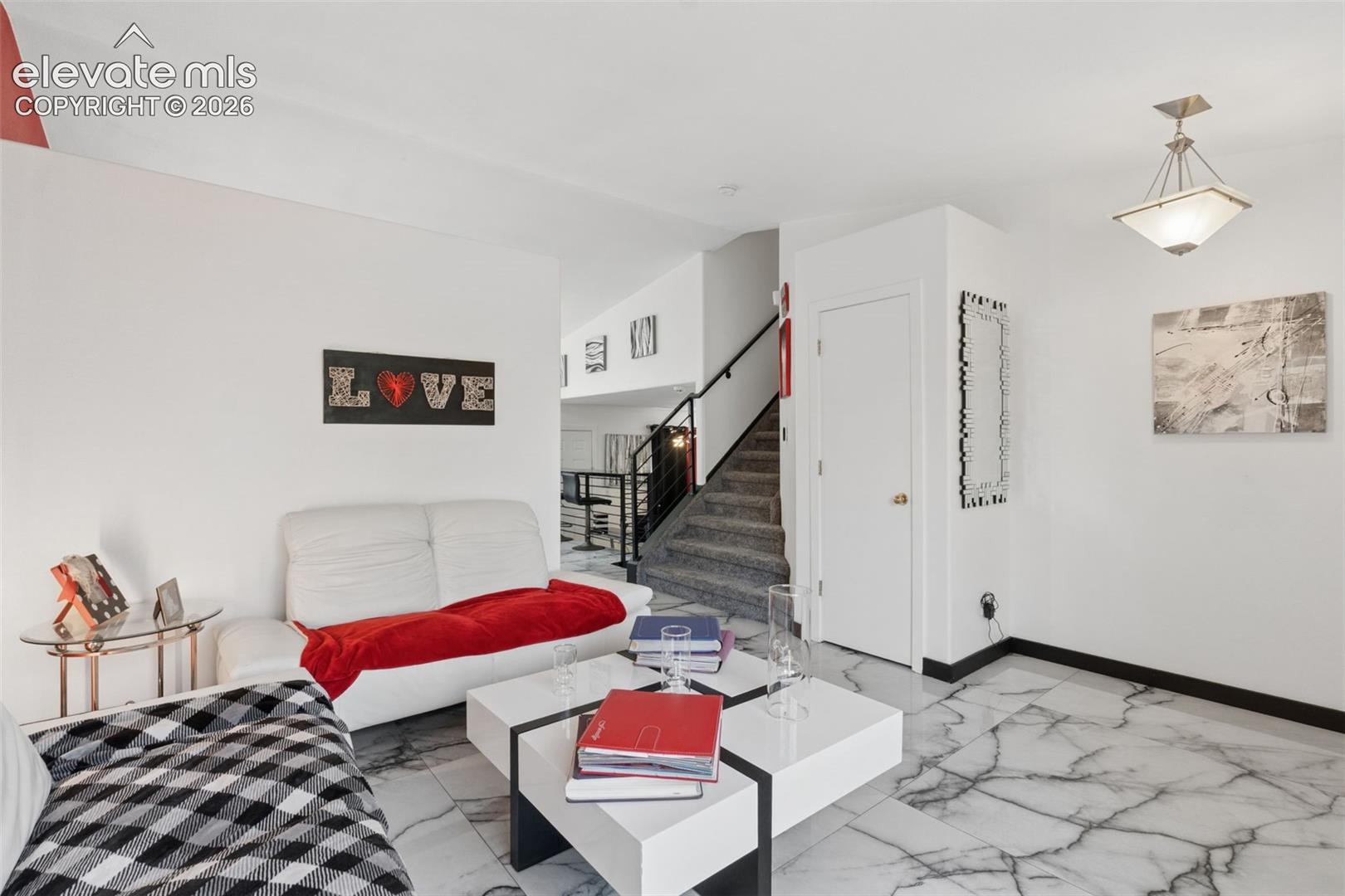 White walls, black trim, and marble-finish flooring
