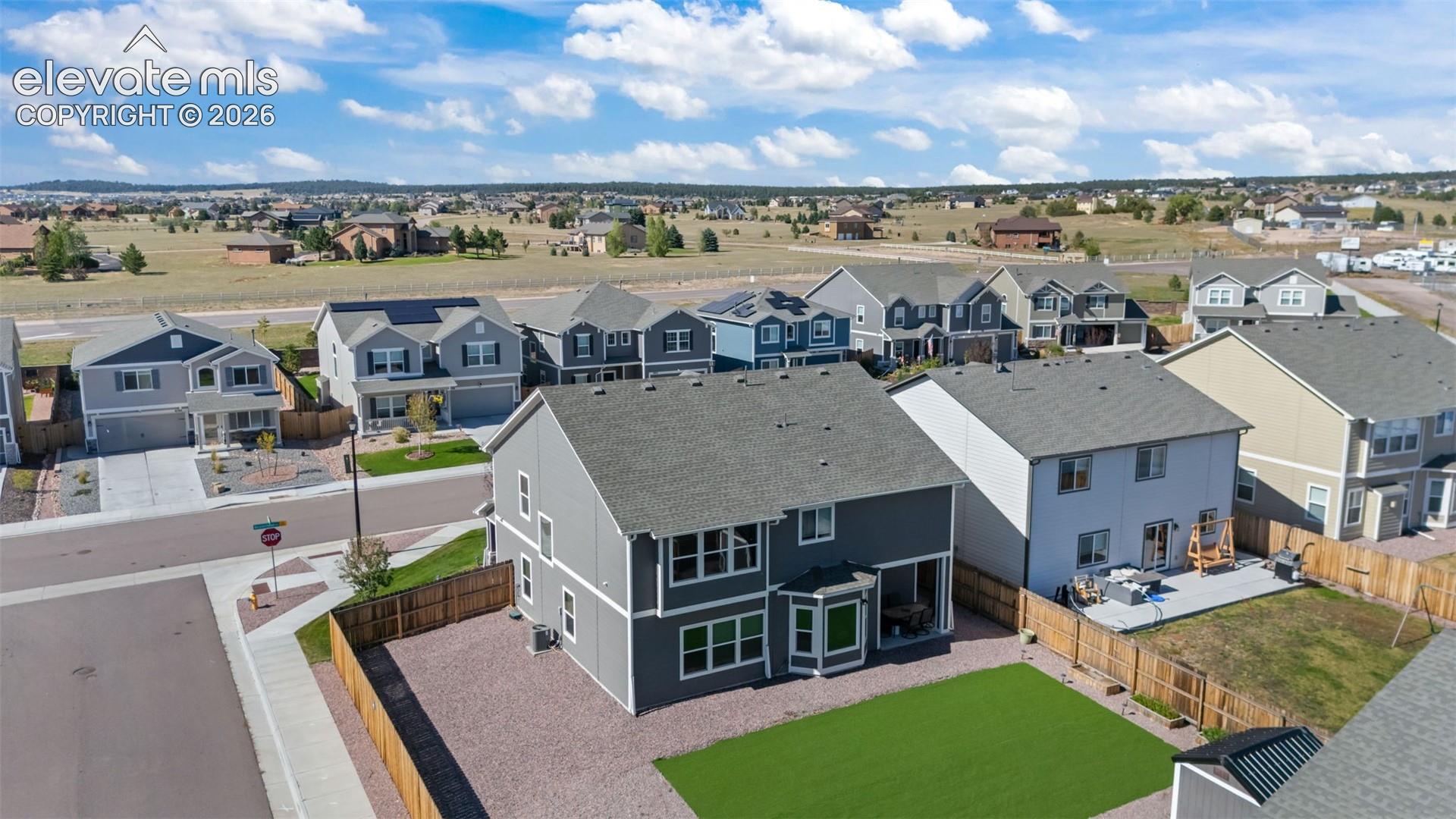 Two-story residence with a gray exterior and a shingled roof, featuring multiple windows