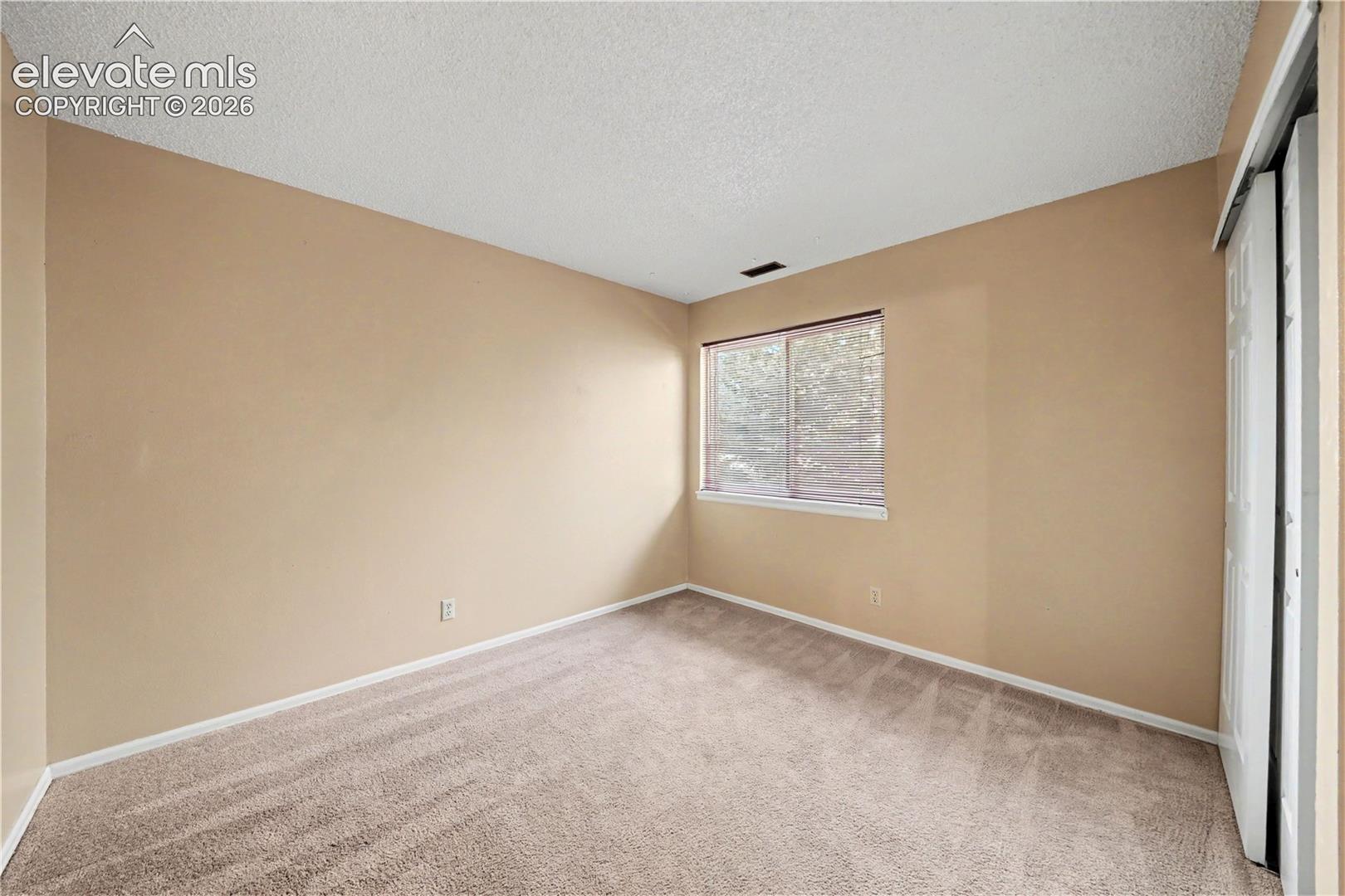 Carpeted bedroom with neutral walls