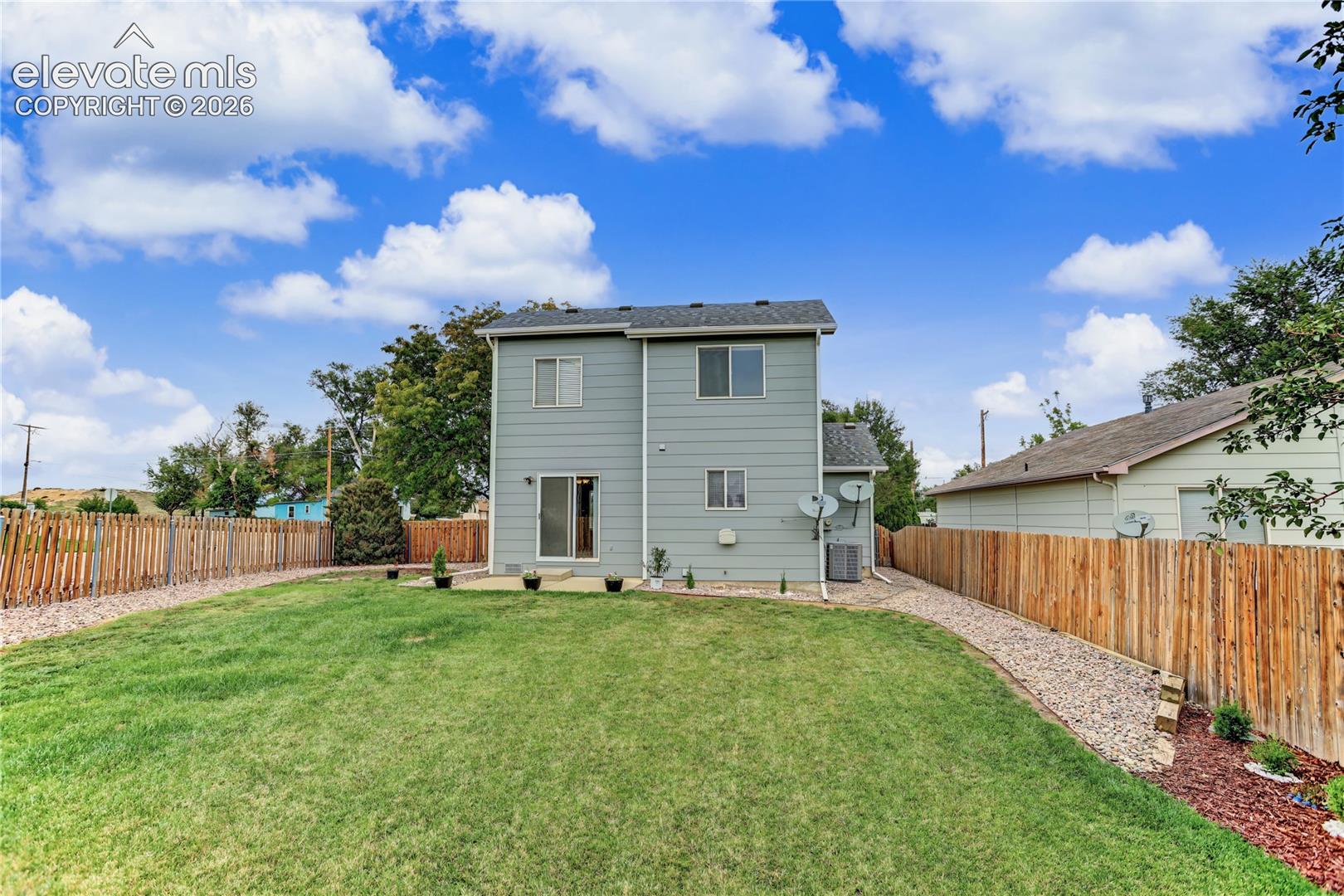Expansive grass lawn with a full wooden privacy fence