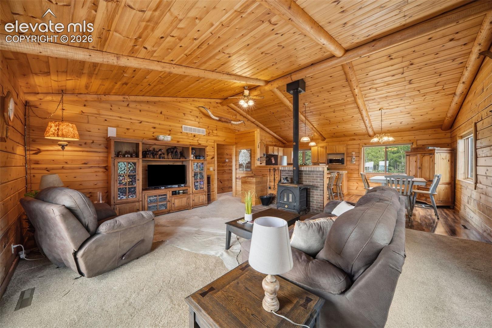 Main level living room with vaulted wood ceilings, walls and open concept