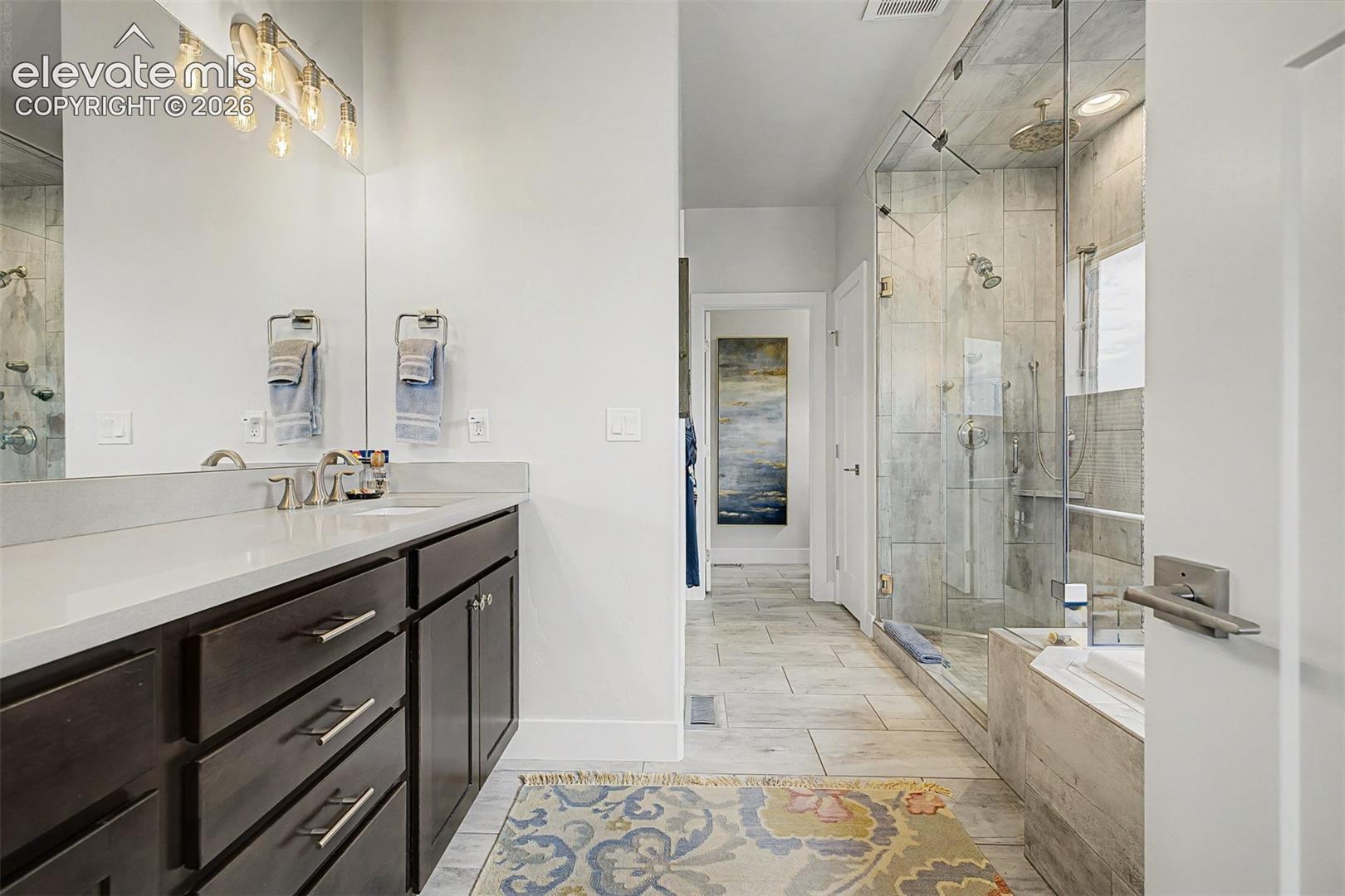 Though this doesn't show the double sinks, it does show the gorgeous, oversized shower with the vented rain shower, with bench seating, part of the soaking tub.