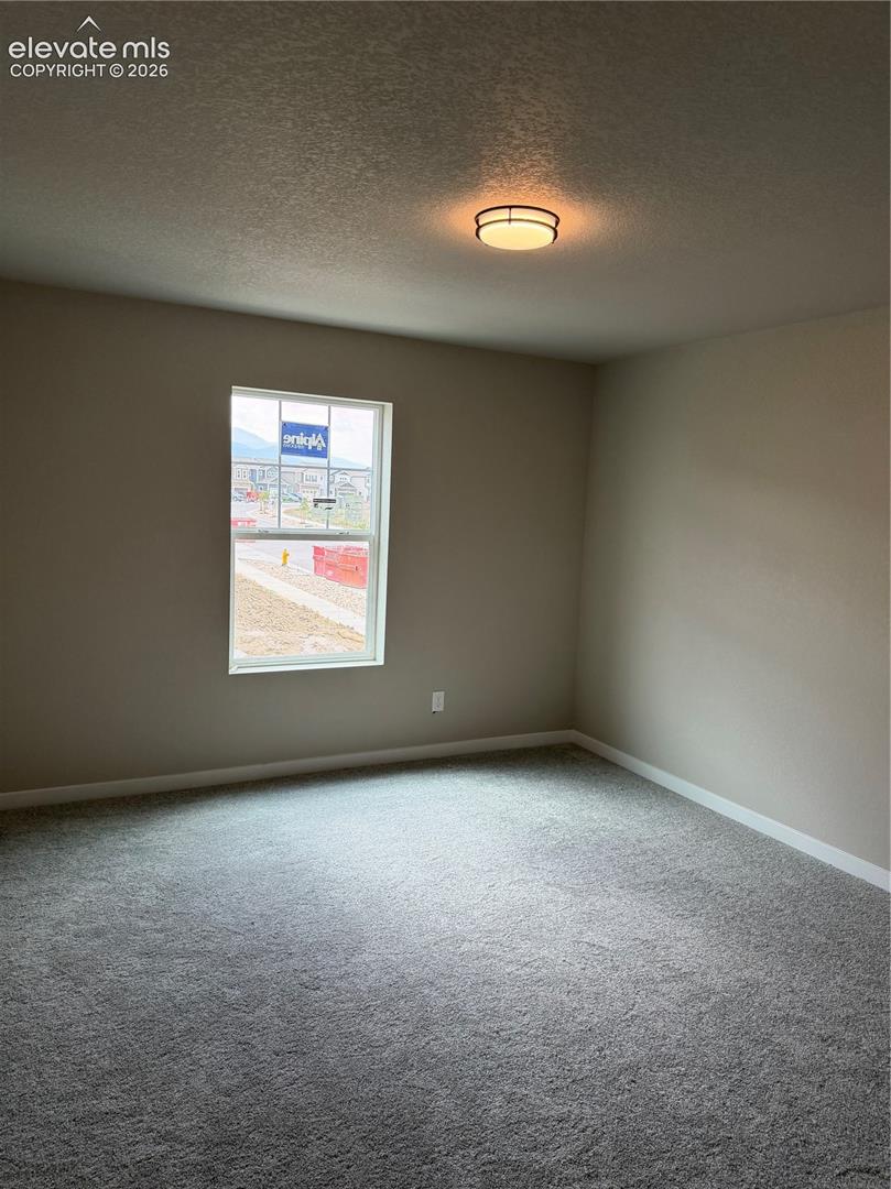 Bedroom with single window, recessed ceiling light, and neutral carpet and walls.