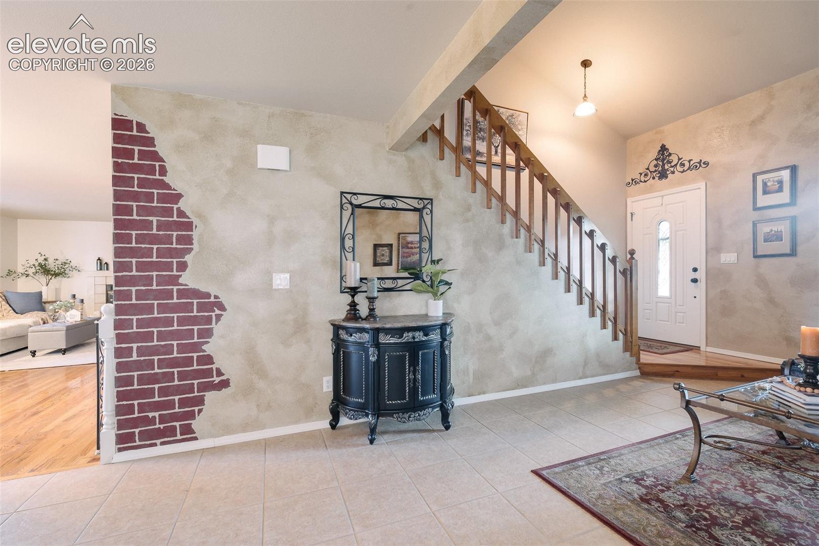 Front foyer with a textured wall and open stair case to the upper level.