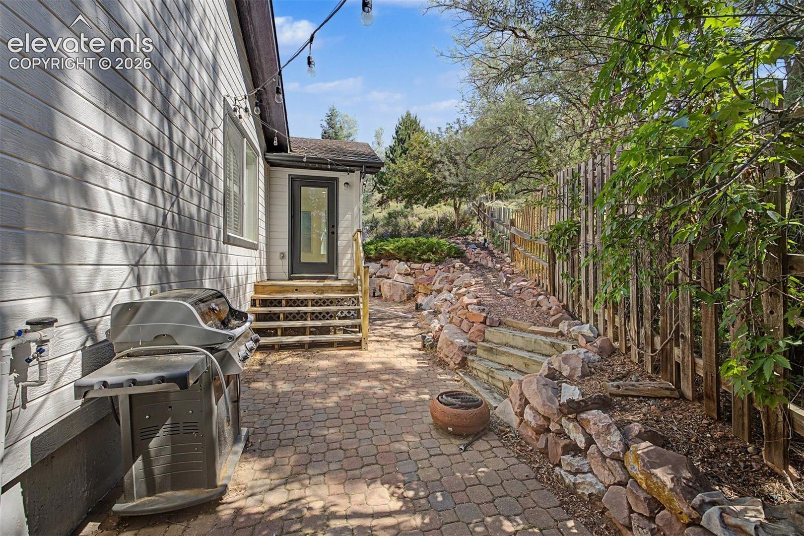 Back of home with stone patio