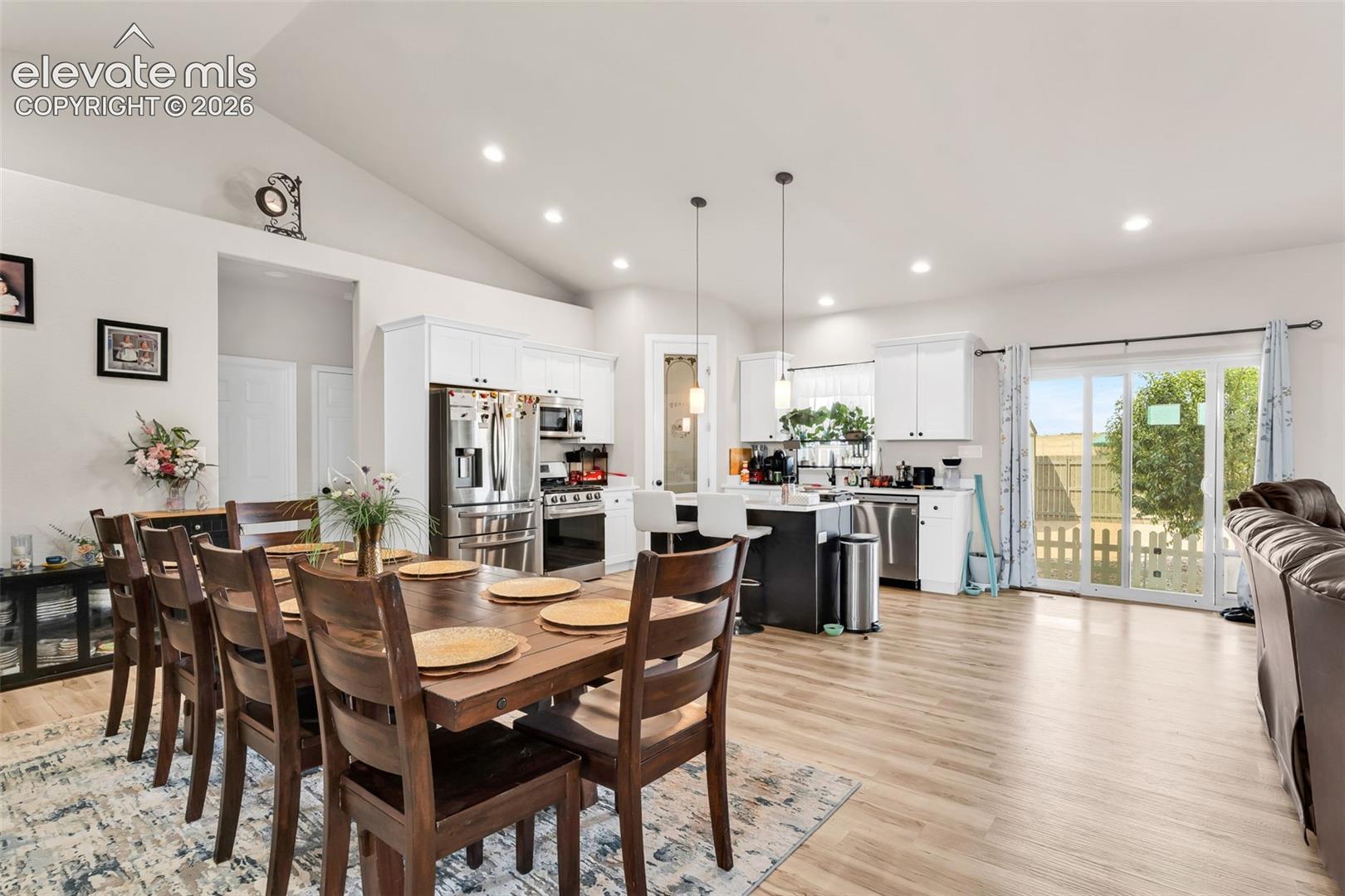 Vaulted ceilings over an open-concept living area with wood-finish flooring