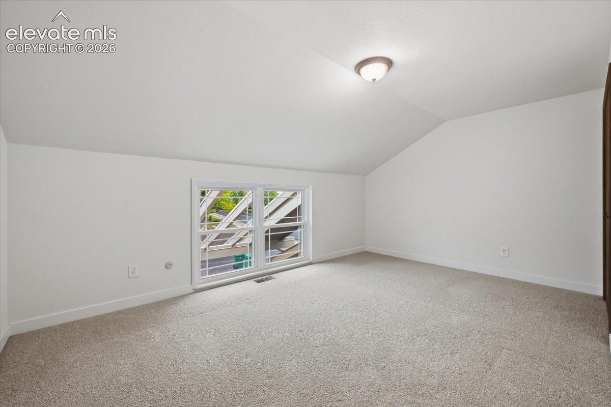 Bedroom 4 - Neutral carpeting and white walls with a sloped ceiling