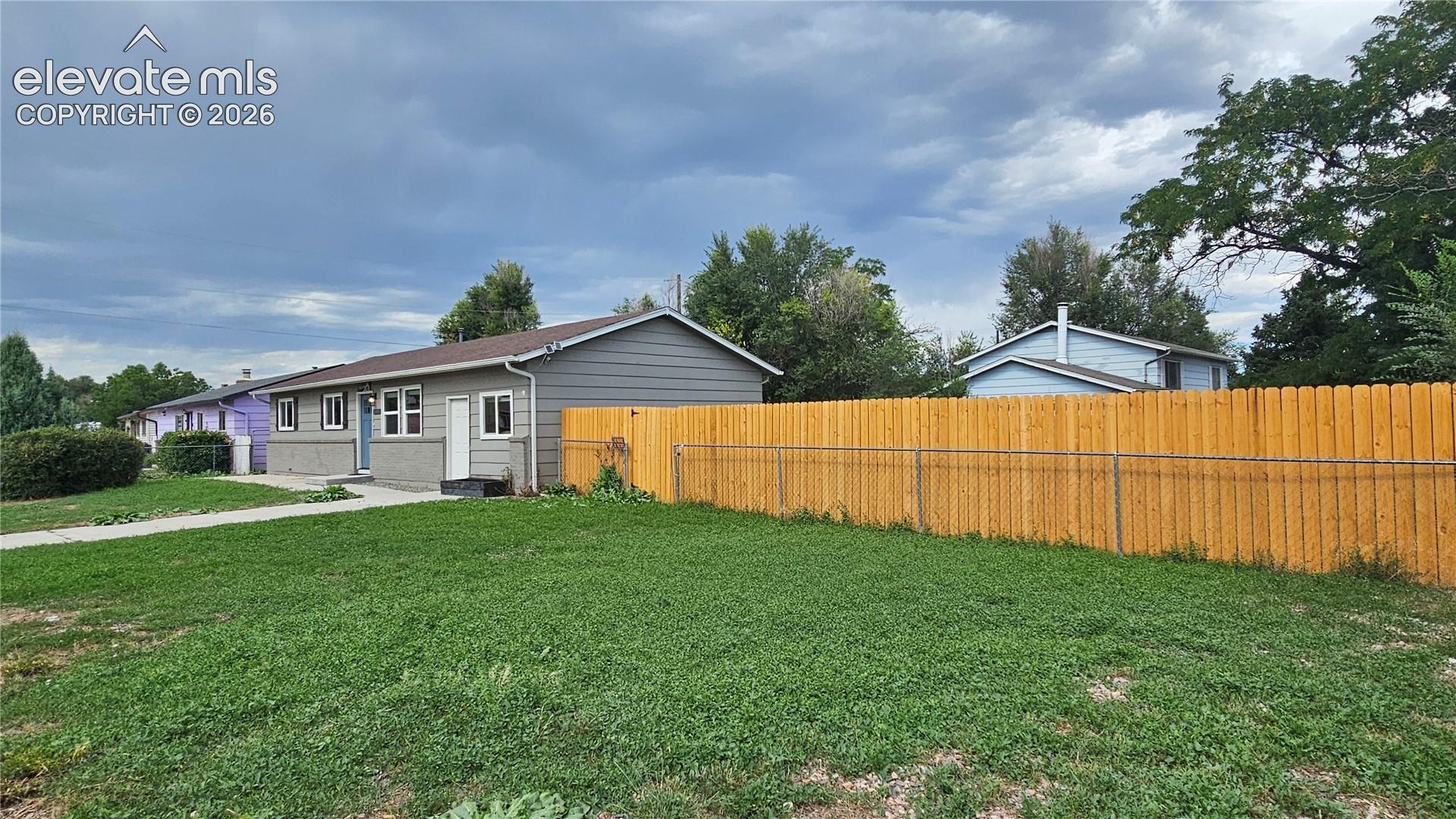 Single-story residence featuring horizontal siding and brick siding, on a large corner lot