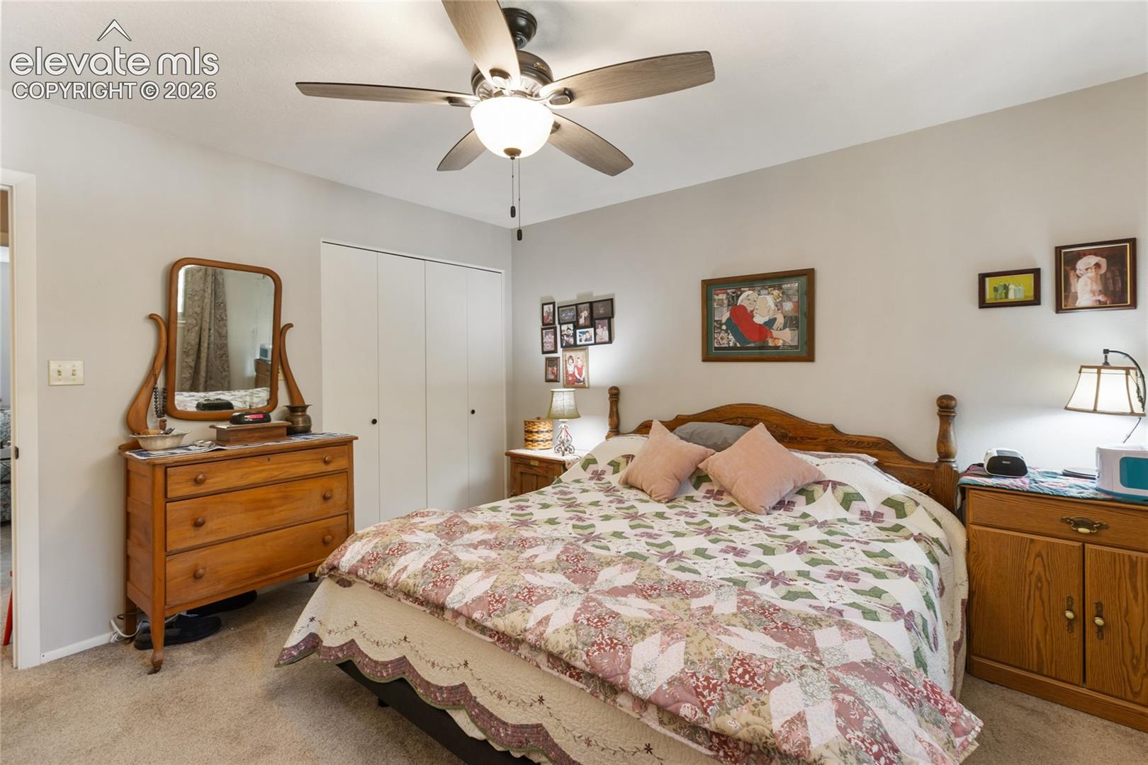 Wall-to-wall carpeting and a ceiling fan with integrated lighting