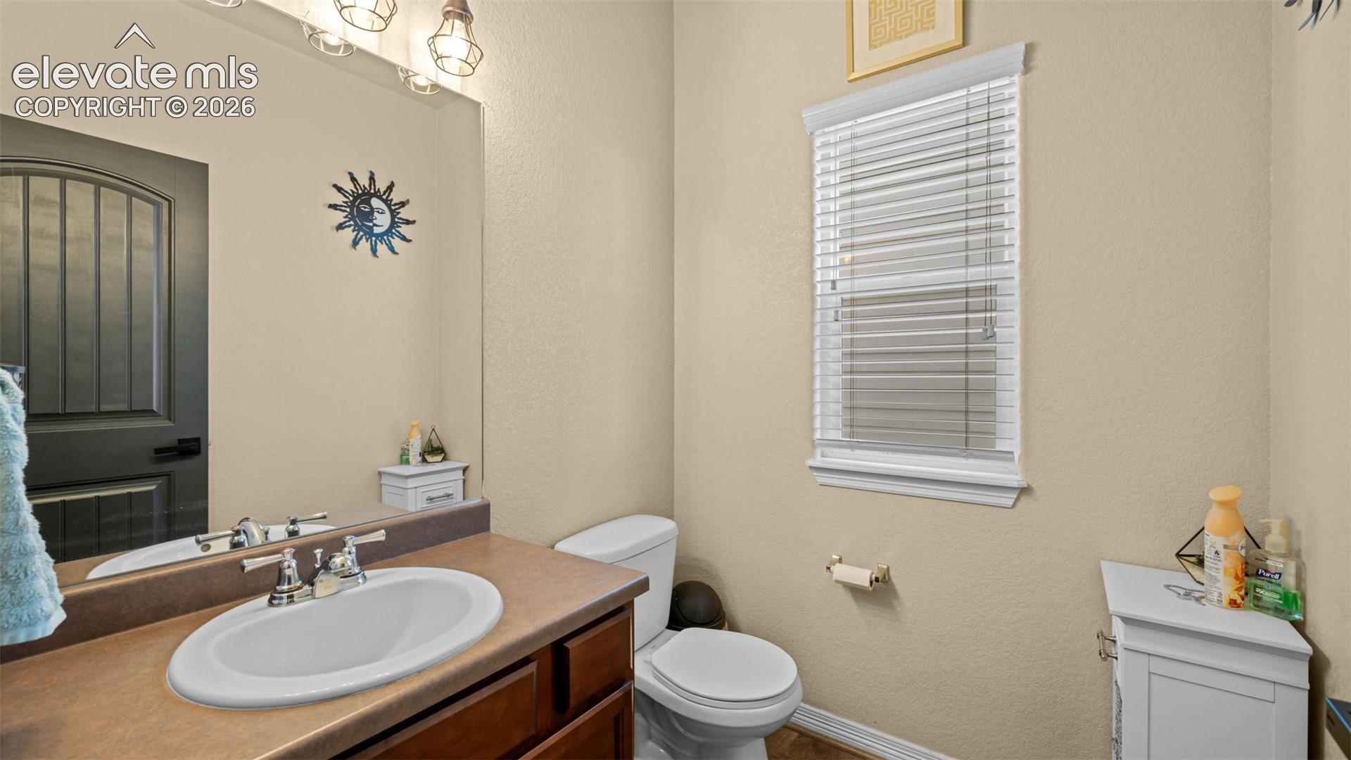 Bathroom featuring a vanity with an oval undermount sink, dual-handle chrome faucet, and a large mirror
