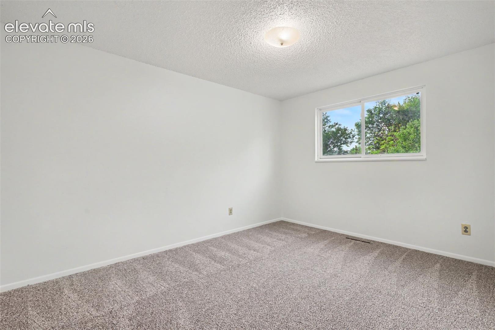 Bright upper level bedroom with updated carpet and fresh paint.