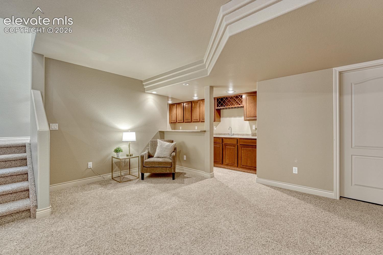 Wet Bar in the Basement Family Room that features upper and lower cabinetry, a built-in wine rack and bar fridge.