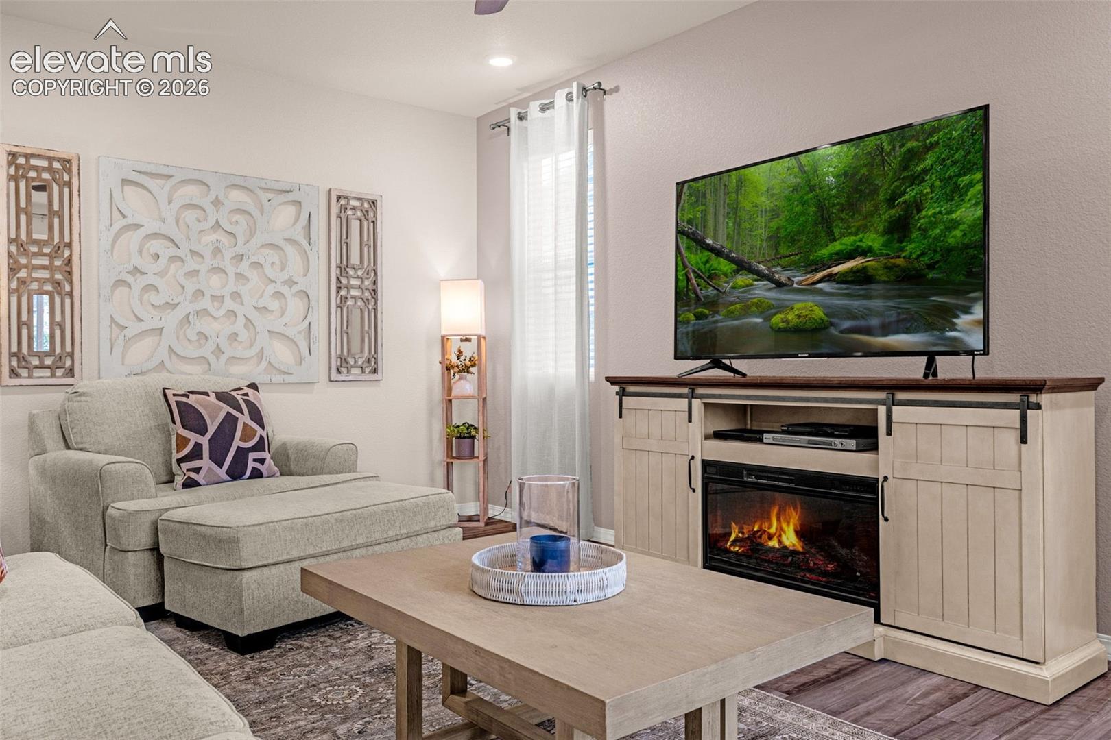 Built-in console with a faux fireplace and barn door accents, recessed lighting, and light-toned wall finishes