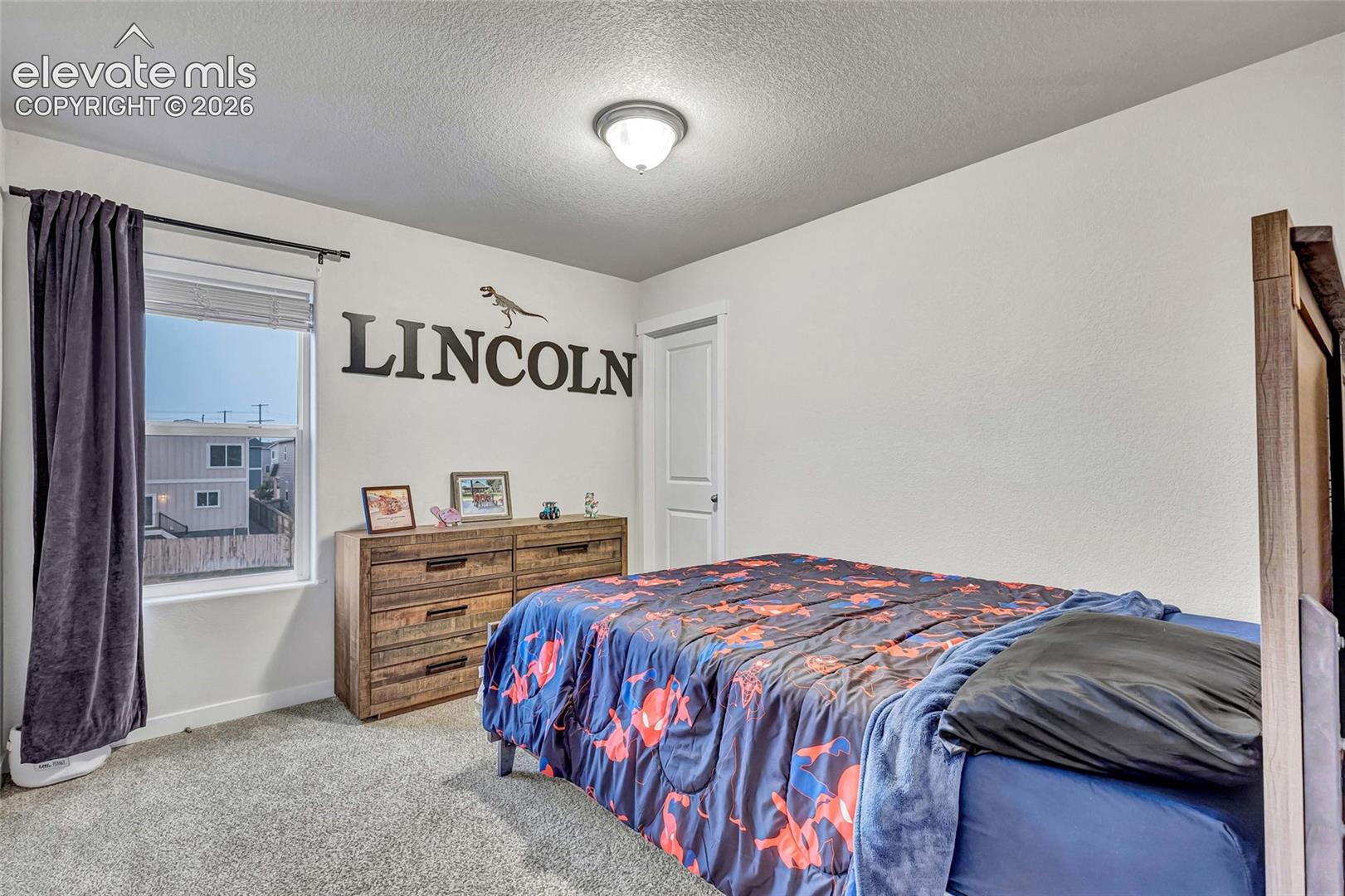Bright room with neutral wall finishes, carpet flooring, a window with blinds, and a flush mount ceiling light