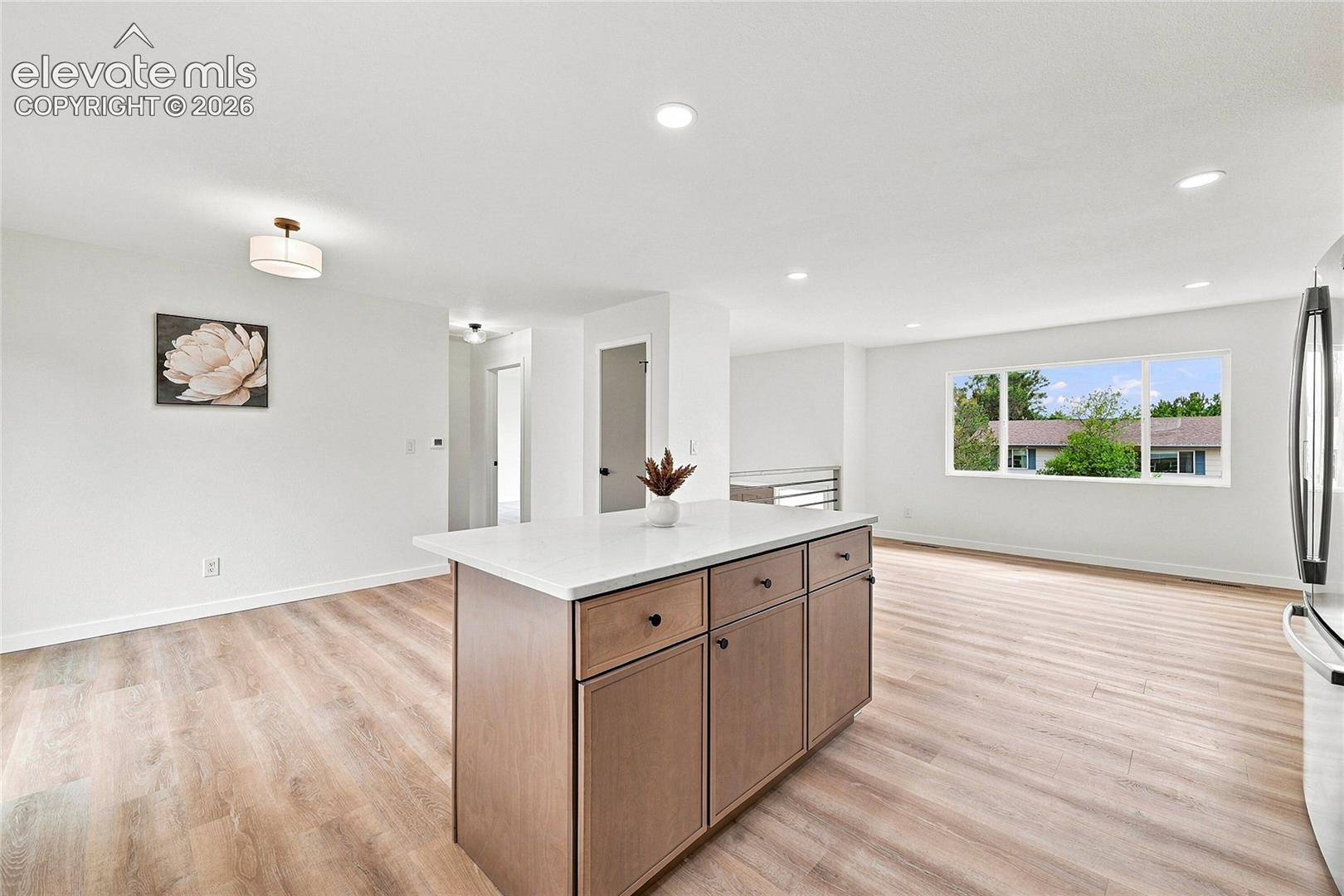 Open concept living space featuring wood-finish flooring and recessed lighting