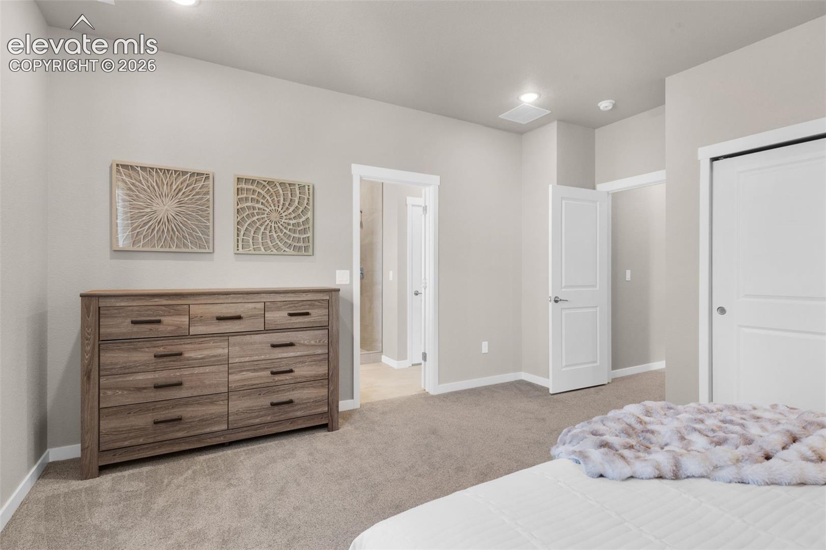 Recessed lighting, light gray wall paint, white trim, and light-colored carpeting