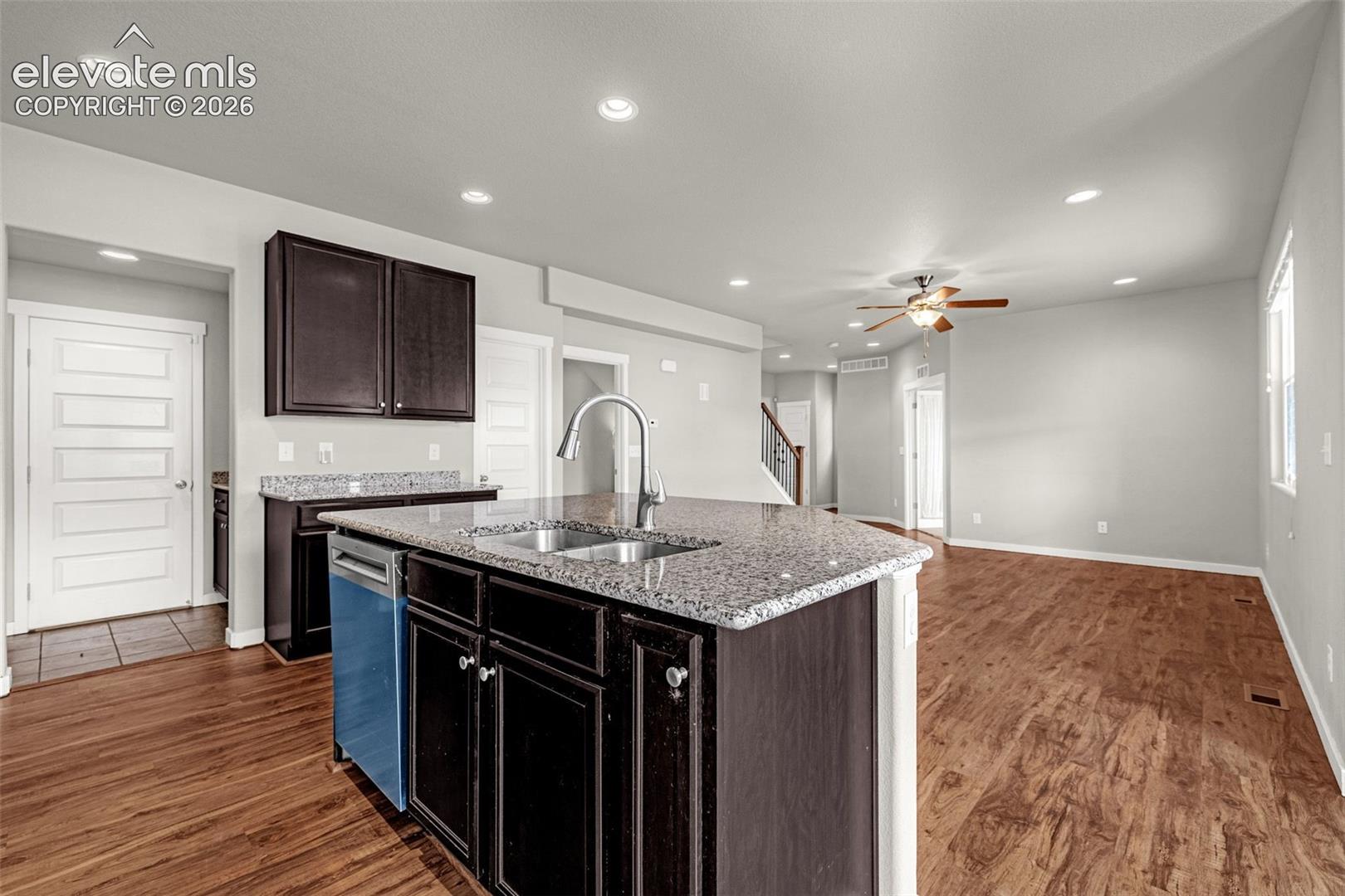 Kitchen island with granite countertop, stainless steel sink, and gooseneck faucet