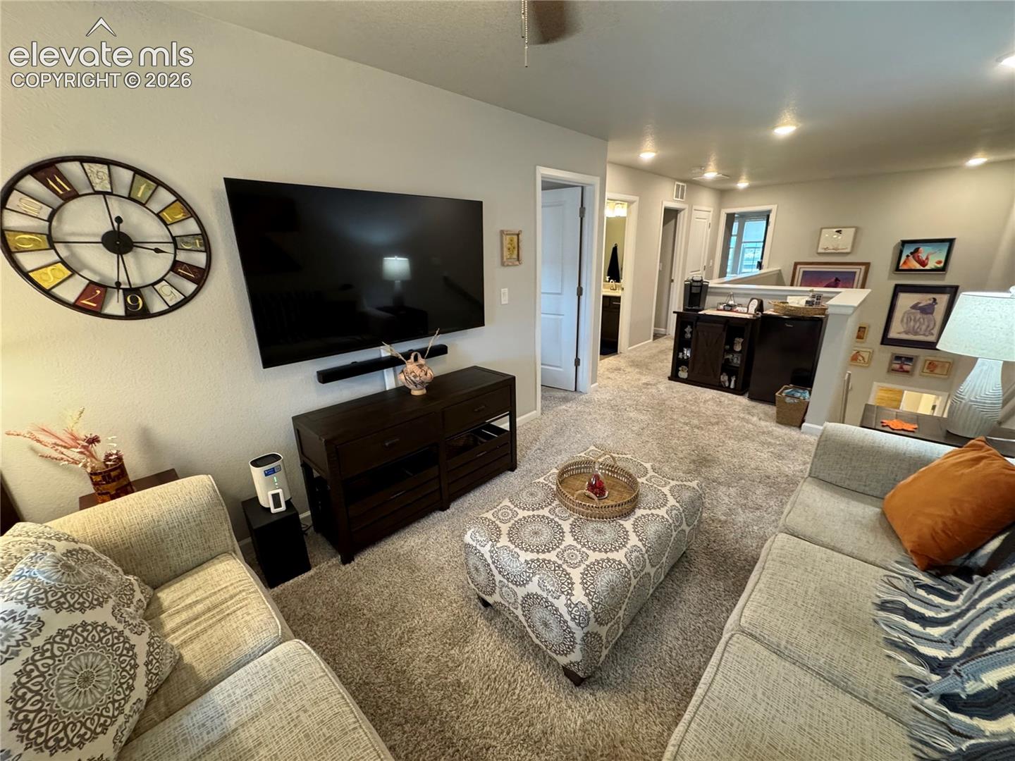 Neutral wall tones, recessed lighting, and wall-to-wall carpeting