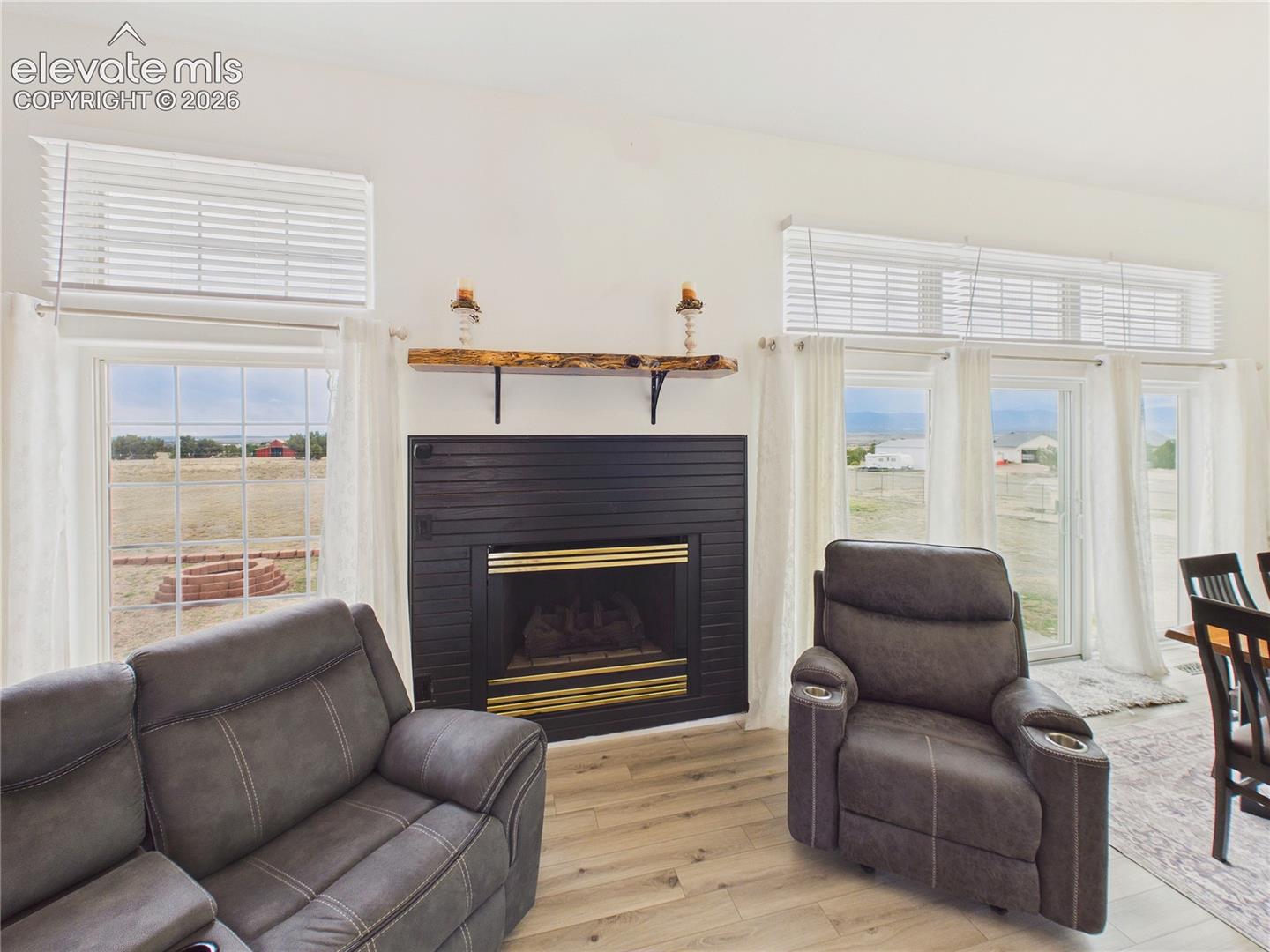 Floor-to-ceiling windows and a striking gas fireplace create a warm, inviting focal point while highlighting the home's scenic views.