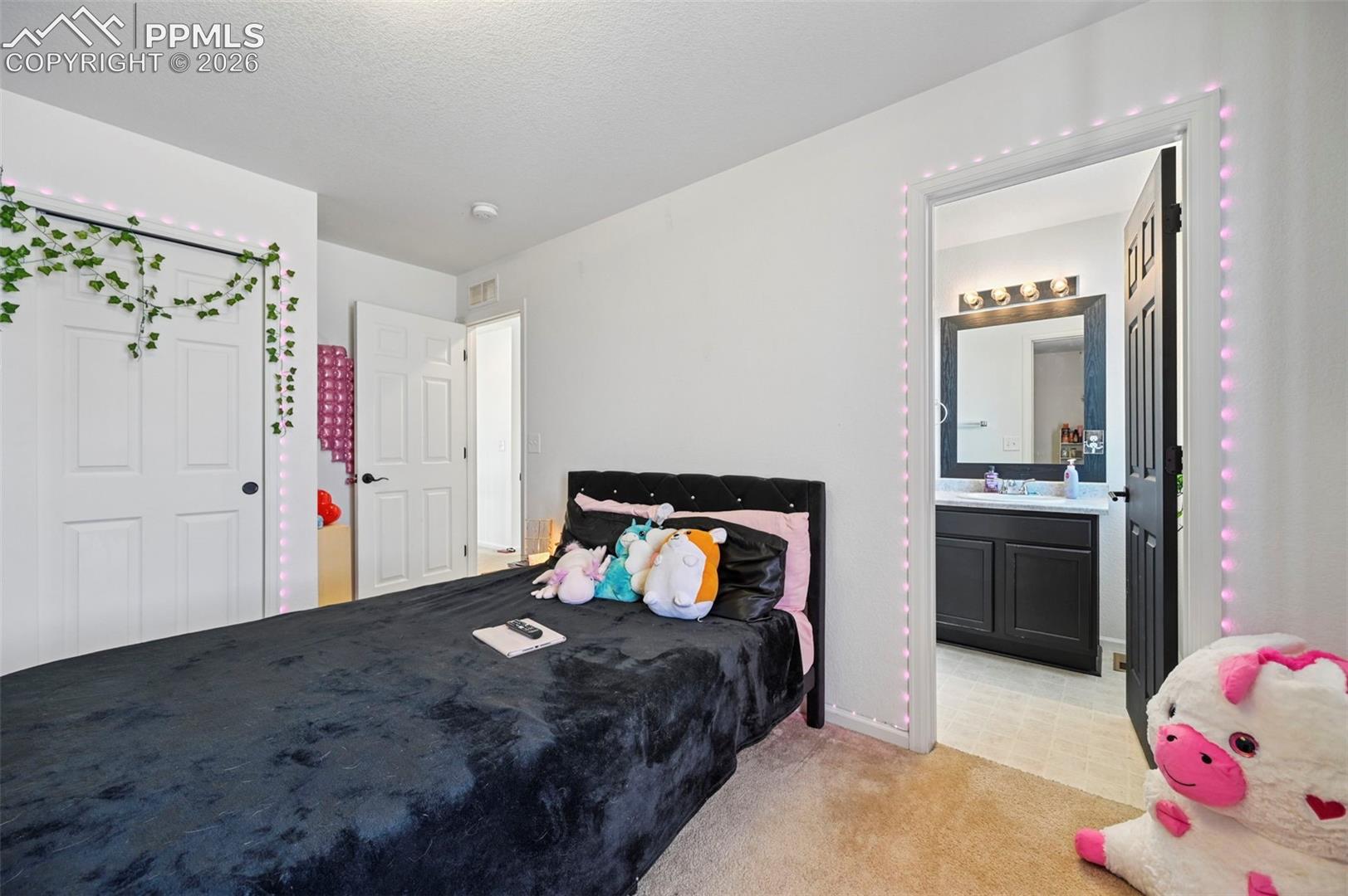 Carpeted bedroom featuring white walls and white paneled doors
