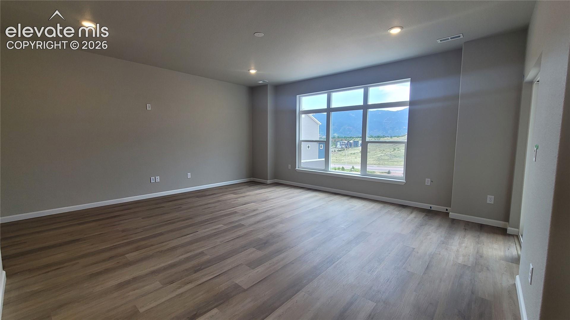 Living room with LVP flooring, LED Lighting, Prewired for Future Ceiling Fan, Abundance of Natural Light, Walks out to Composite Deck! 