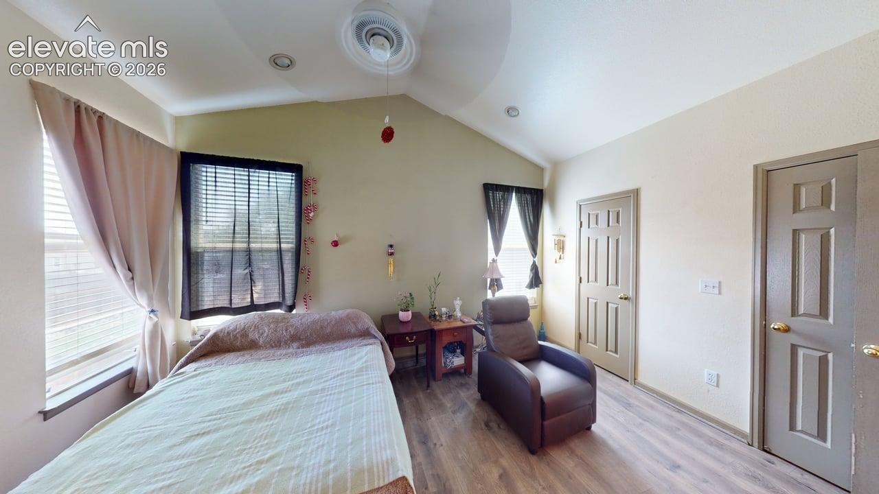 Interior room featuring vaulted ceilings, ceiling fan, recessed lighting, and wood-finish flooring