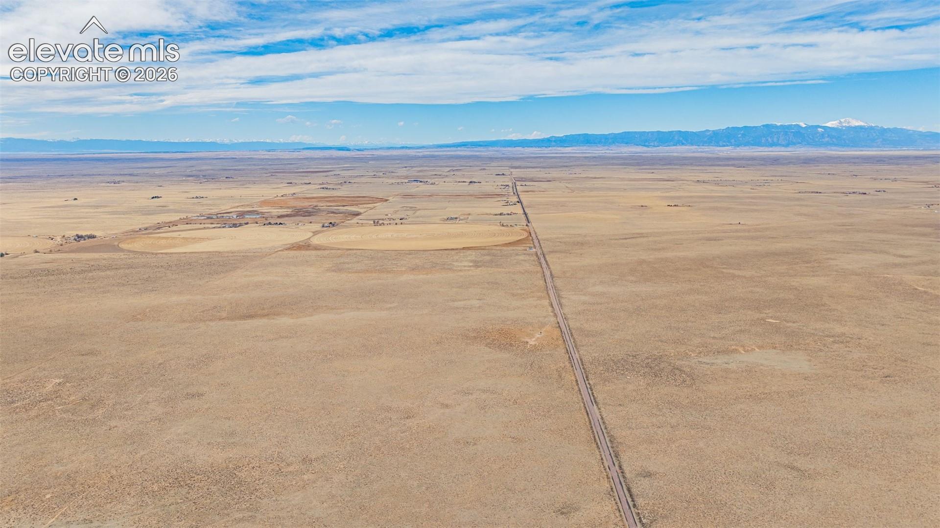 Expansive acreage featuring flat terrain and mountain range backdrops