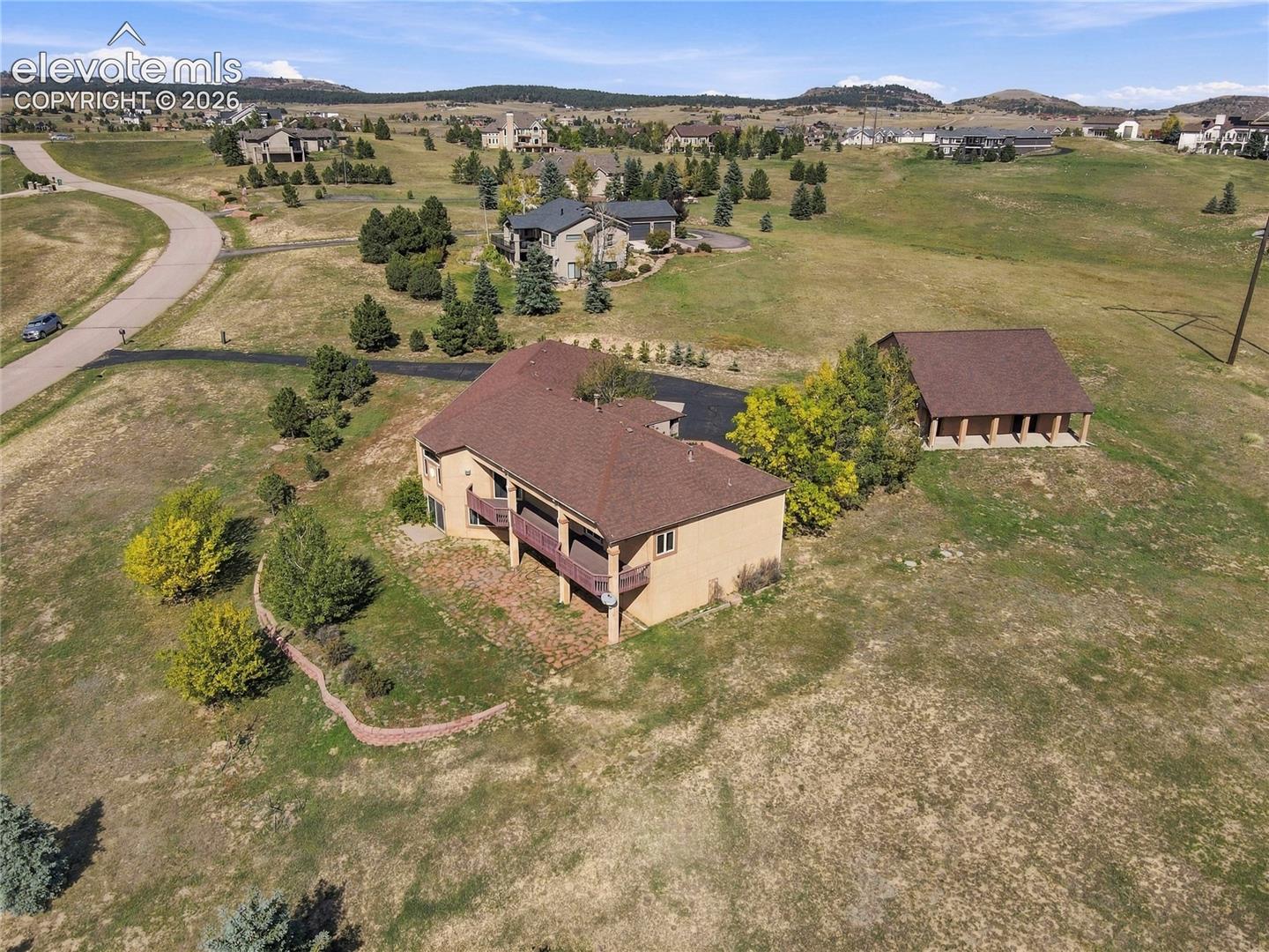 Expansive property with easy-care stucco exterior, generous covered deck, and a detached outbuilding with covered parking
