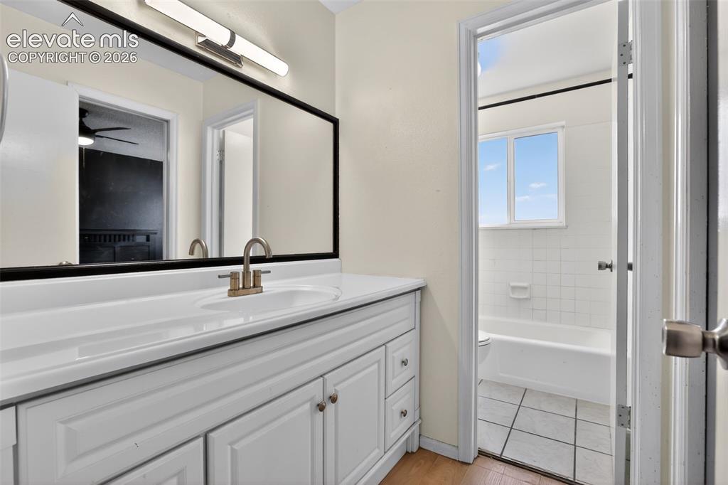 Bathroom vanity featuring a white cabinetry, integrated sink, and brushed nickel faucet