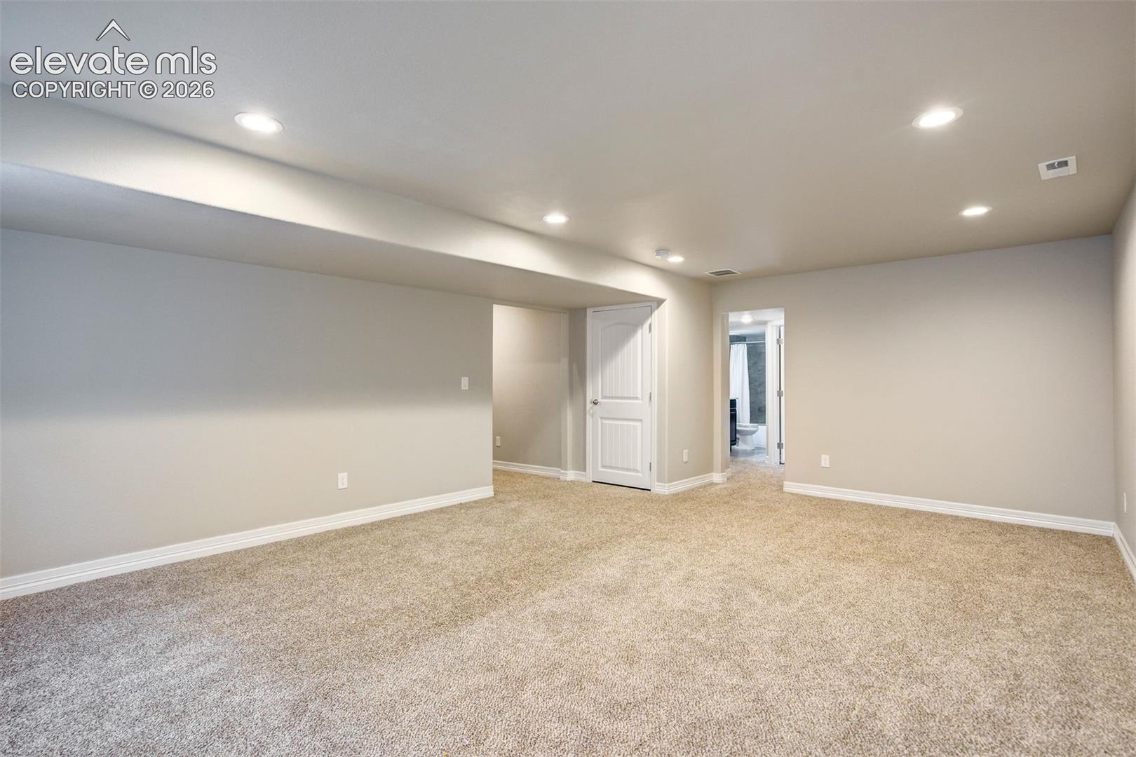 Open floor plan with plush carpeting, recessed lighting, and a neutral color palette