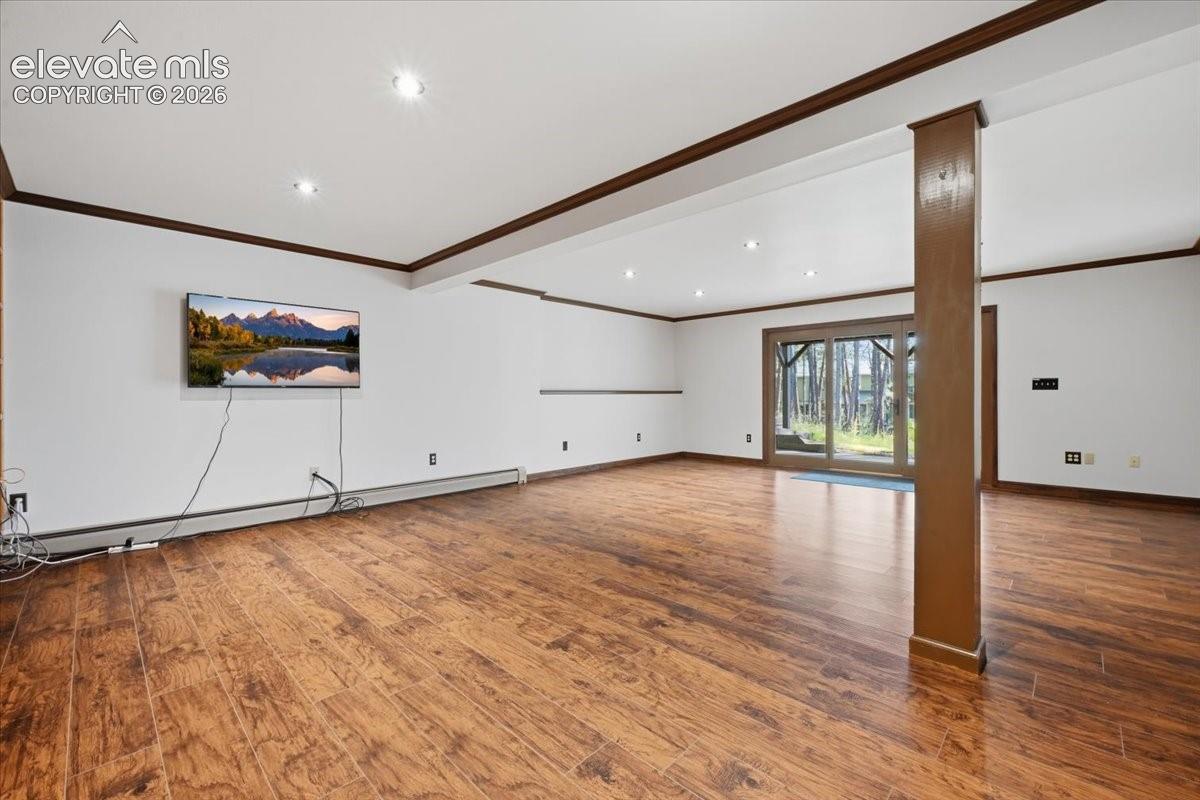 Wood-finish flooring, recessed lighting, and white walls with dark trim