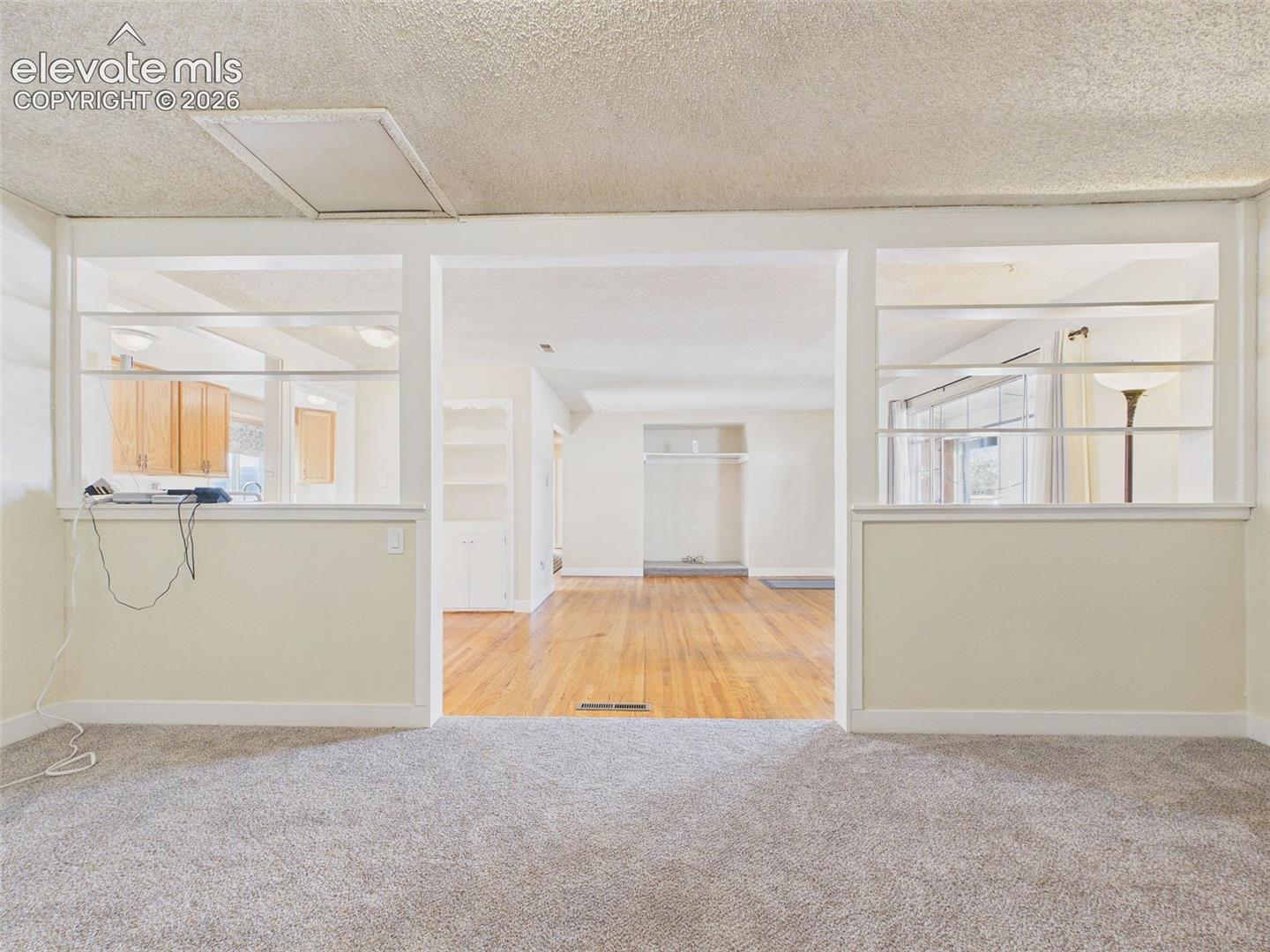 Spacious carpeted bonus room with built-in shelving, closet storage, and an open layout offering multiple possibilities.