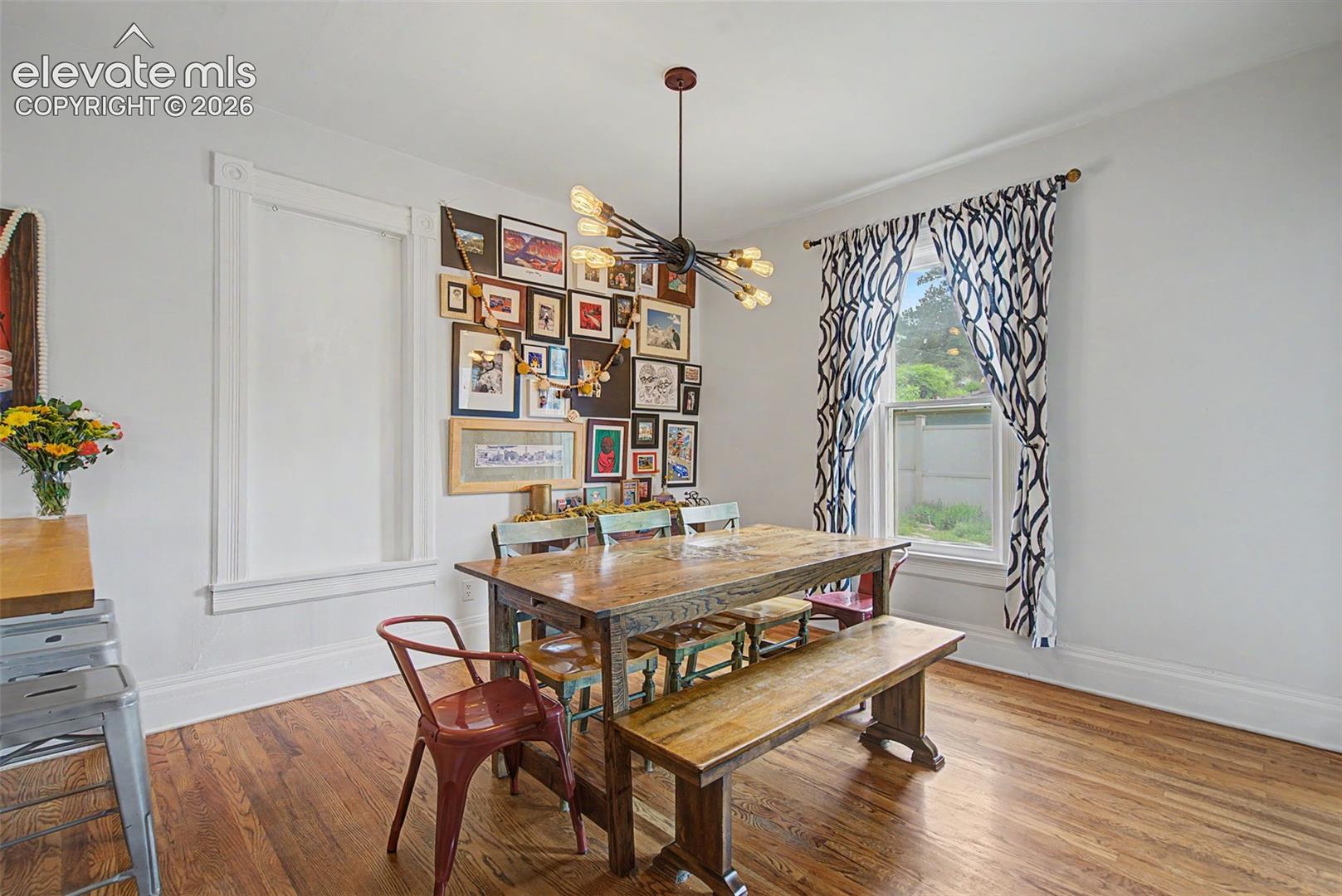 Dining area featuring hardwood flooring throughout and a modern chandelier