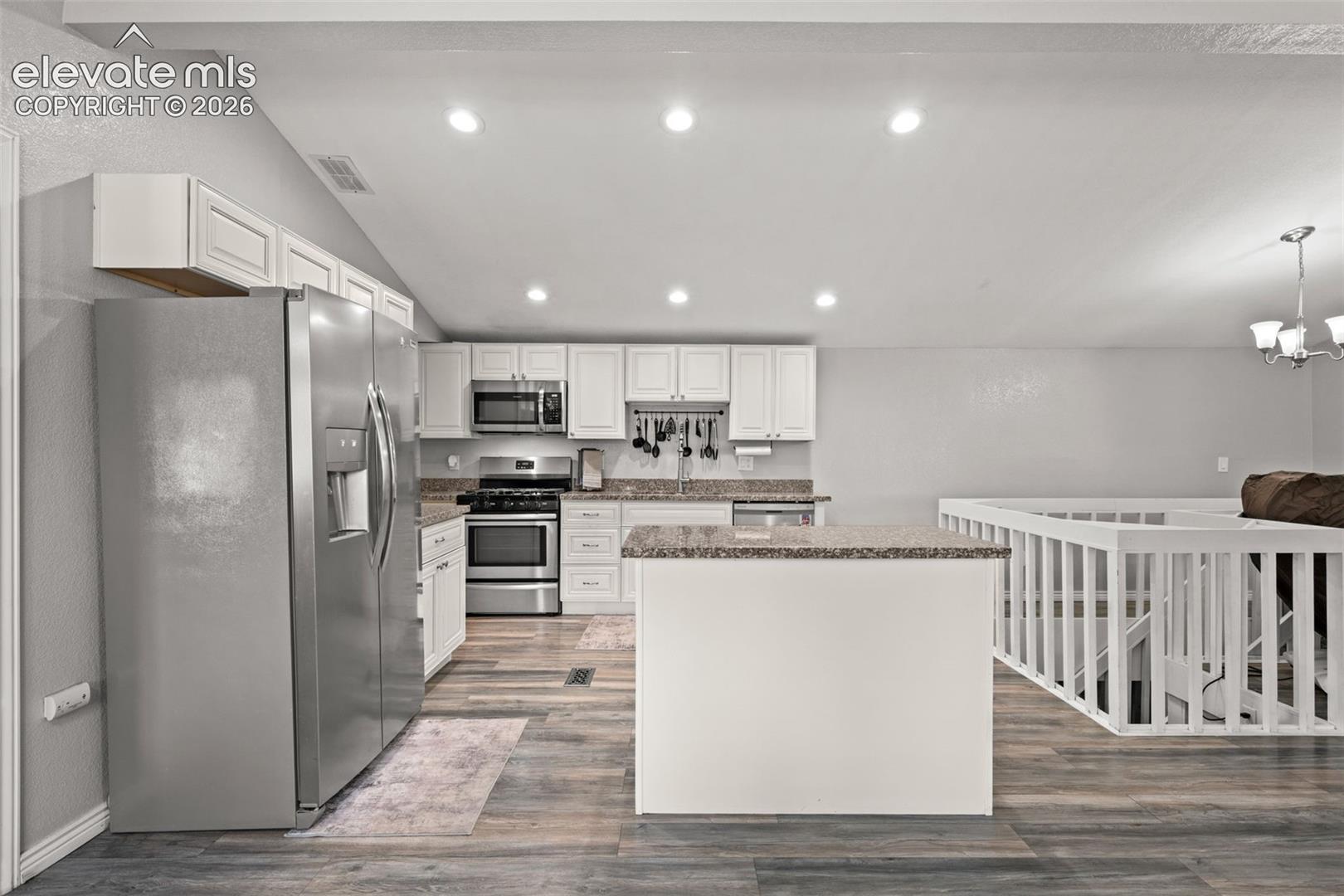 Kitchen featuring white cabinetry, stone-finish countertops, stainless steel appliances, wood-finish flooring, and recessed lighting