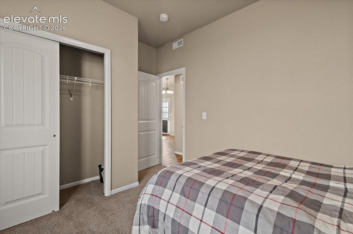 Carpeted room with a sliding closet door, wire shelving, and neutral wall tones