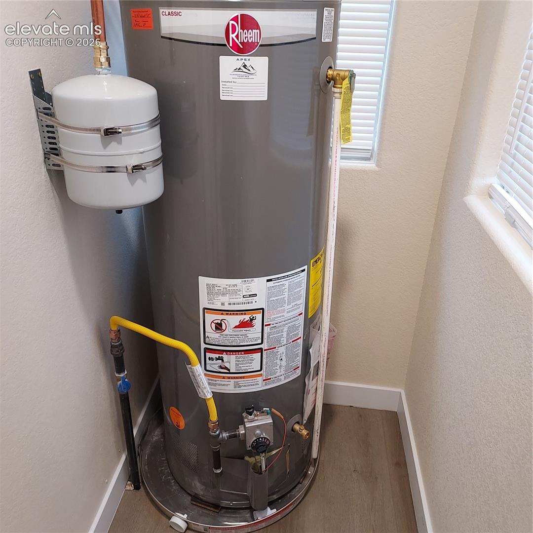 Rheem Classic water heater featuring an expansion tank, copper piping, and a metal drain pan