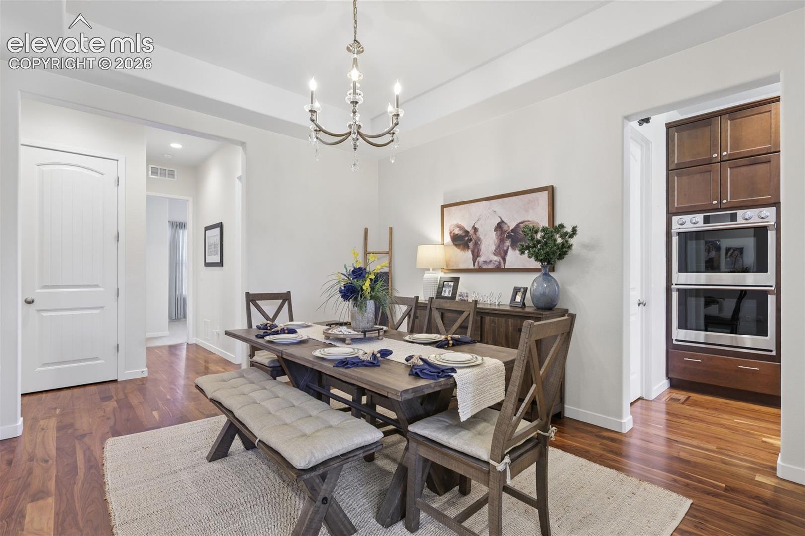 Hardwood flooring, recessed lighting, and a chandelier fixture