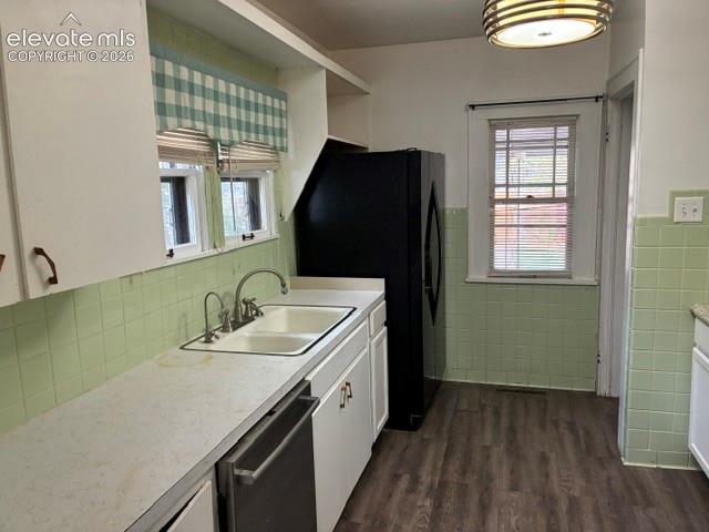 Kitchen featuring white cabinetry, light green tiled backsplash, and wood-finish flooring