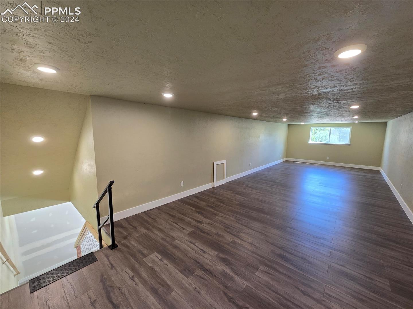 Loft/bonus room featuring a textured ceiling and dark hardwood / wood-style flooring