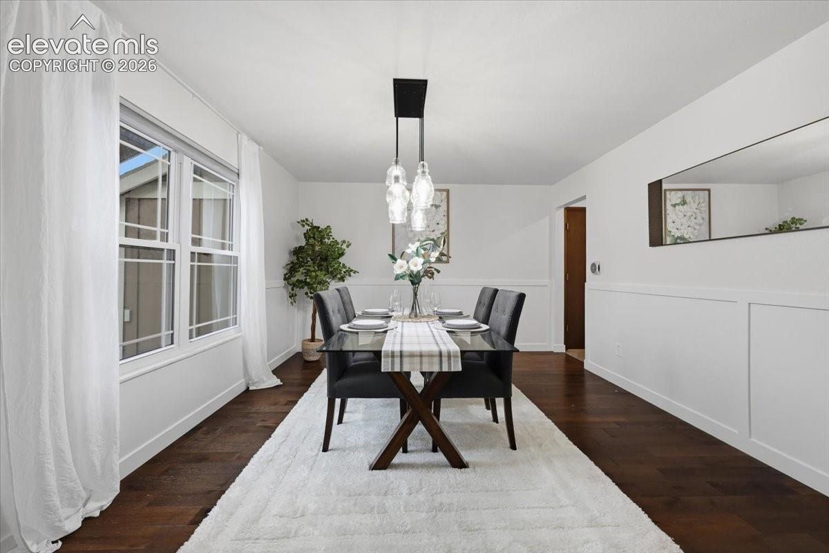 Elegant dining room showcasing dark wood flooring, and custom trim