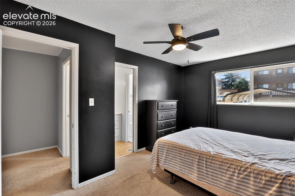 Bedroom featuring dark-painted walls and light-toned carpet flooring